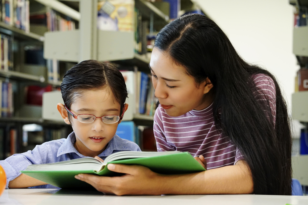 Tutor is helping a kid to read